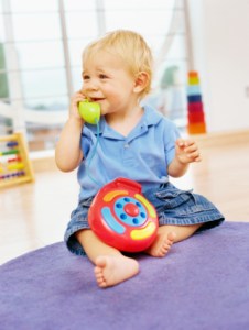 baby boy playing with a toy telephone